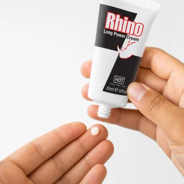 Eine erbsengroße Menge Rhino Long Power Creme auf einer Fingerspitze, darüber die 30-ml-Tube