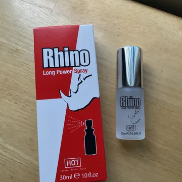 Die Verpackung des Rhino Long Power Spray und die 10-ml-Flasche auf einem Holztisch